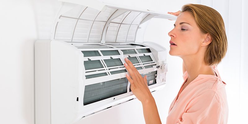 Woman Checking an Air Conditioner.