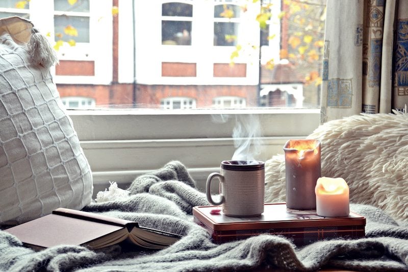 Cozy home. Candles, book and cup of tea, learn how a furnace works.