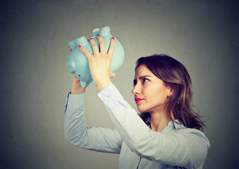 Young worried woman with empty piggy bank because of the rising costs of R22 in Beaufort, NC.