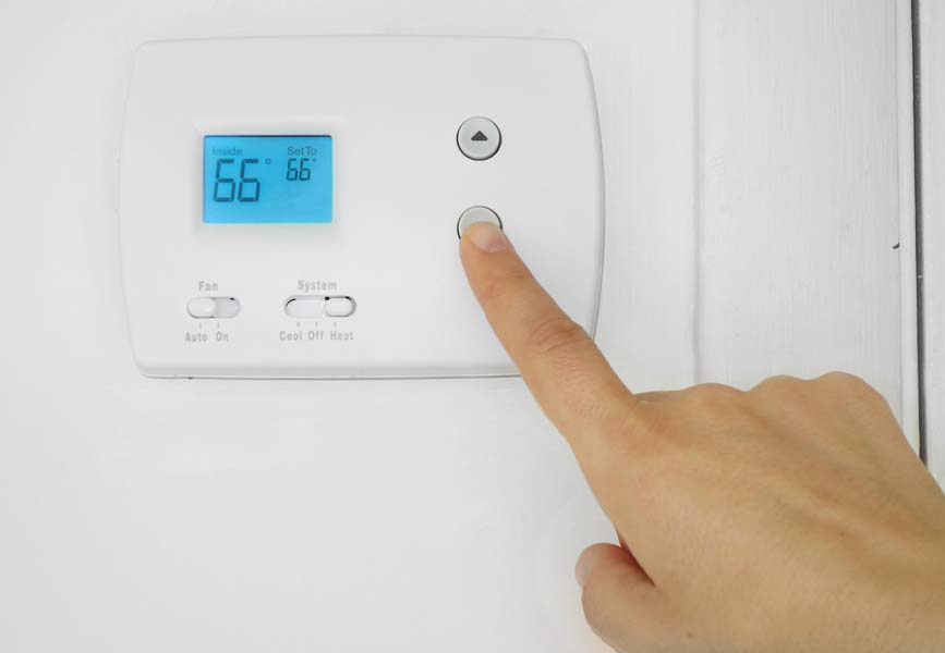 Thermostat on the wall showing 66 degrees.