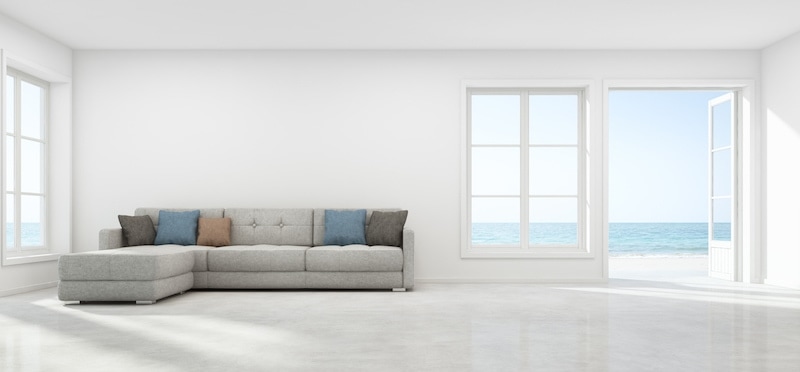 A very clean, white living room with an ocean view.