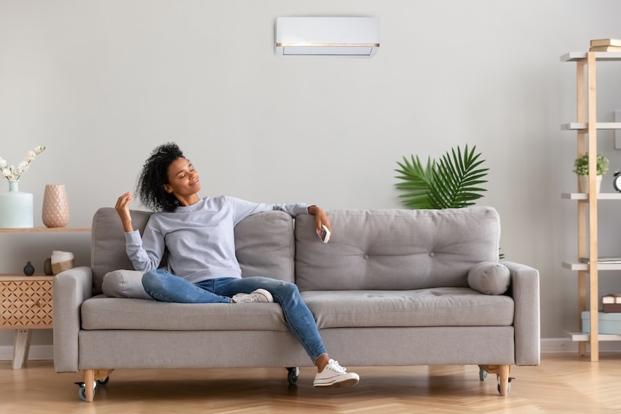 African young relaxed woman sitting on couch breathing fresh air. ﻿What Indoor Air Quality Accessories Can Help Keep Me Healthy?