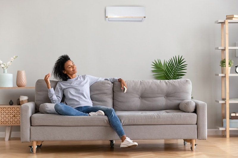 A woman relaxing on a couch - What Accessories Can Help With Indoor Air Quality?