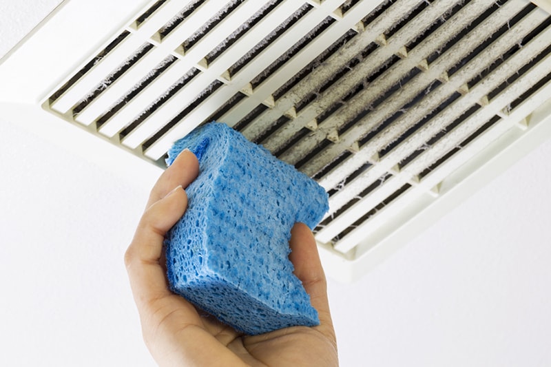 Cleaning Bathroom Fan Vent Cover with Sponge.