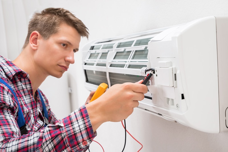 Man fixing ac wall unit.