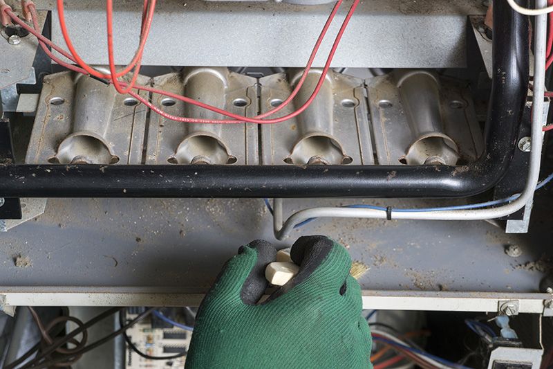 Image of someone working on a furnace. How Do I Know When I Need a New Furnace?